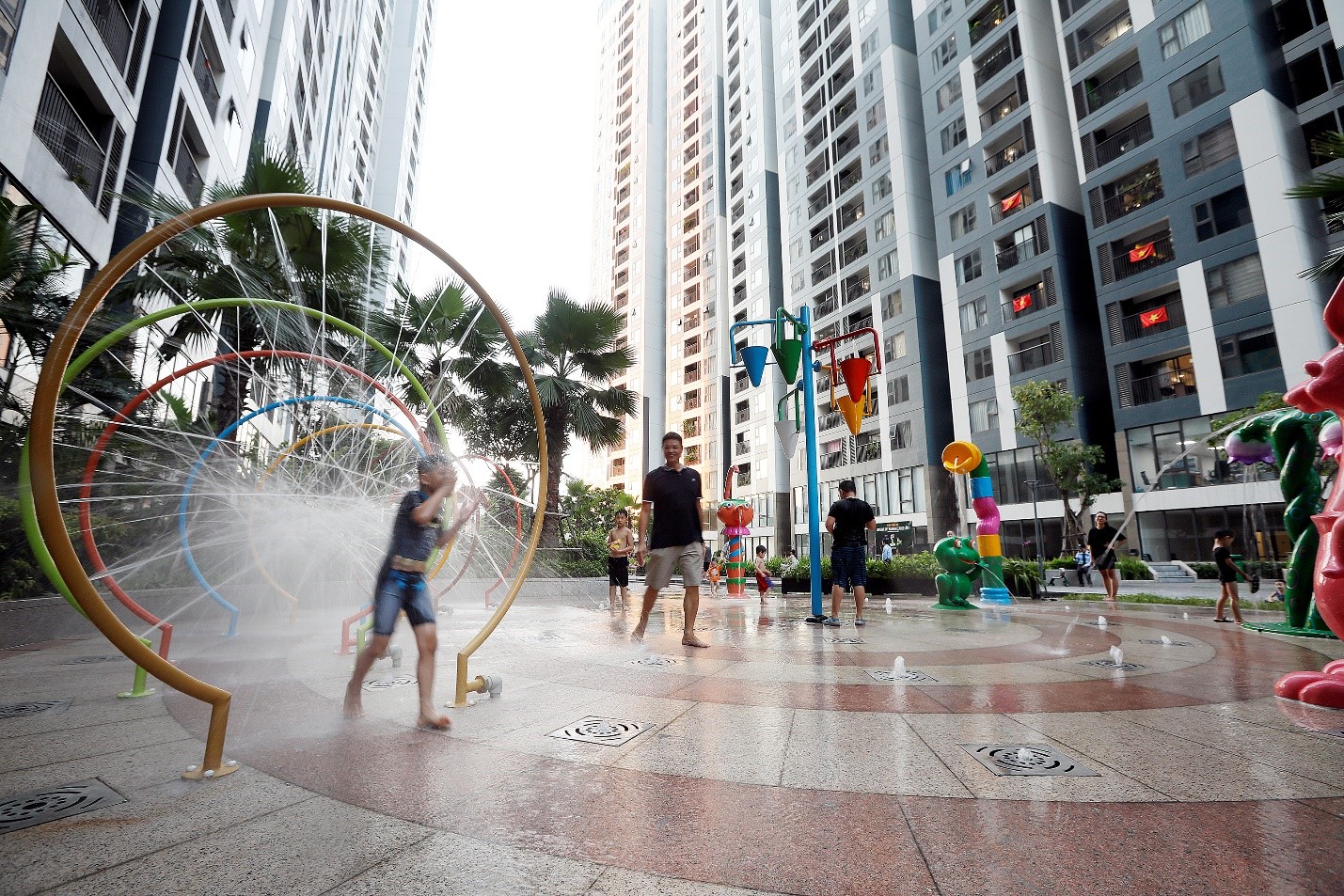 B&ecirc;n cạnh khu vườn tr&ecirc;n m&aacute;i rực rỡ sắc m&agrave;u, dưới ch&acirc;n t&ograve;a nh&agrave;, chủ đầu tư c&ograve;n ch&uacute; trọng đầu tư kh&ocirc;ng gian vui chơi cho cư d&acirc;n như: khu nhạc nước, khu vui chơi trẻ em, những con đường dạo bộ rợp b&oacute;ng c&acirc;y xanh. (Ảnh chụp trước ng&agrave;y 1.5.2021).