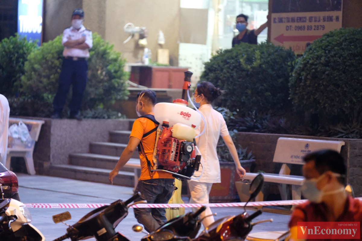 C&aacute;n bộ y tế d&ugrave;ng m&aacute;y phun khử khuẩn khu&ocirc;n vi&ecirc;n xung quanh chung cư.