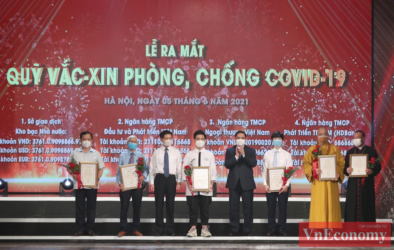 Thủ tướng Ch&iacute;nh phủ Phạm Minh Ch&iacute;nh c&ugrave;ng Bộ trưởng Bộ T&agrave;i ch&iacute;nh Hồ Đức Phớc trao chứng nhận v&agrave; hoa cảm ơn những đ&oacute;ng g&oacute;p của đại diện c&aacute;c tầng lớp nh&acirc;n d&acirc;n v&agrave;o Quỹ vaccine ph&ograve;ng, chống Covid-19.&nbsp;