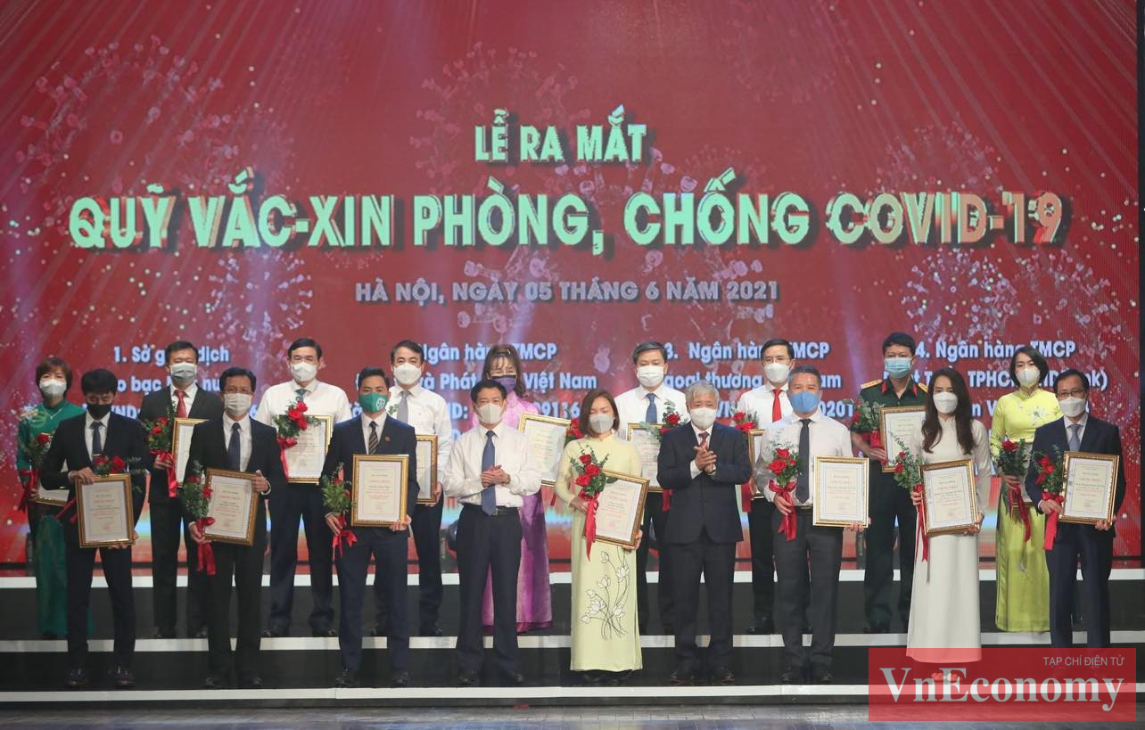 Chủ tịch Ủy ban Trung ương MTTQ Việt Nam Đỗ Văn Chiến cùng Bộ trưởng Bộ Tài chính Hồ Đức Phớc trao chứng nhận và hoa cảm ơn các doanh nghiệp đóng góp cho Quỹ. 