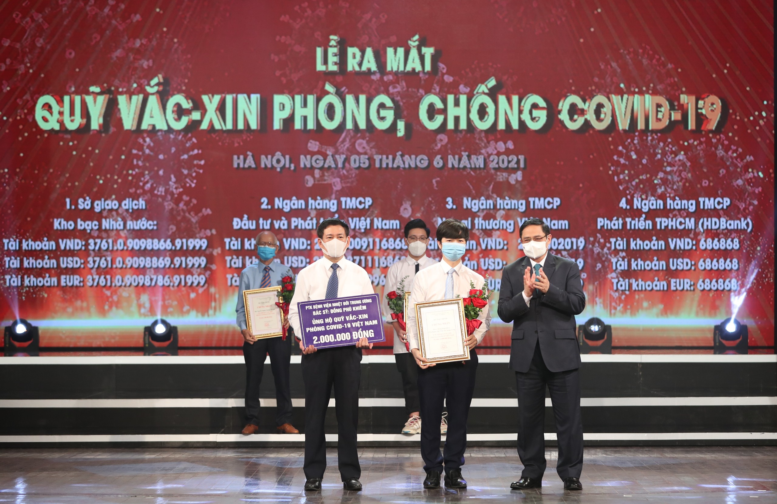 Thủ tướng Chính phủ Phạm Minh Chính trao chứng nhận, hoa cảm ơn em Lê Đức Hiếu, học sinh Trường Phạm Hồng Thái, Ba Đình, Hà Nội, 15 tuổi. Ảnh VGP