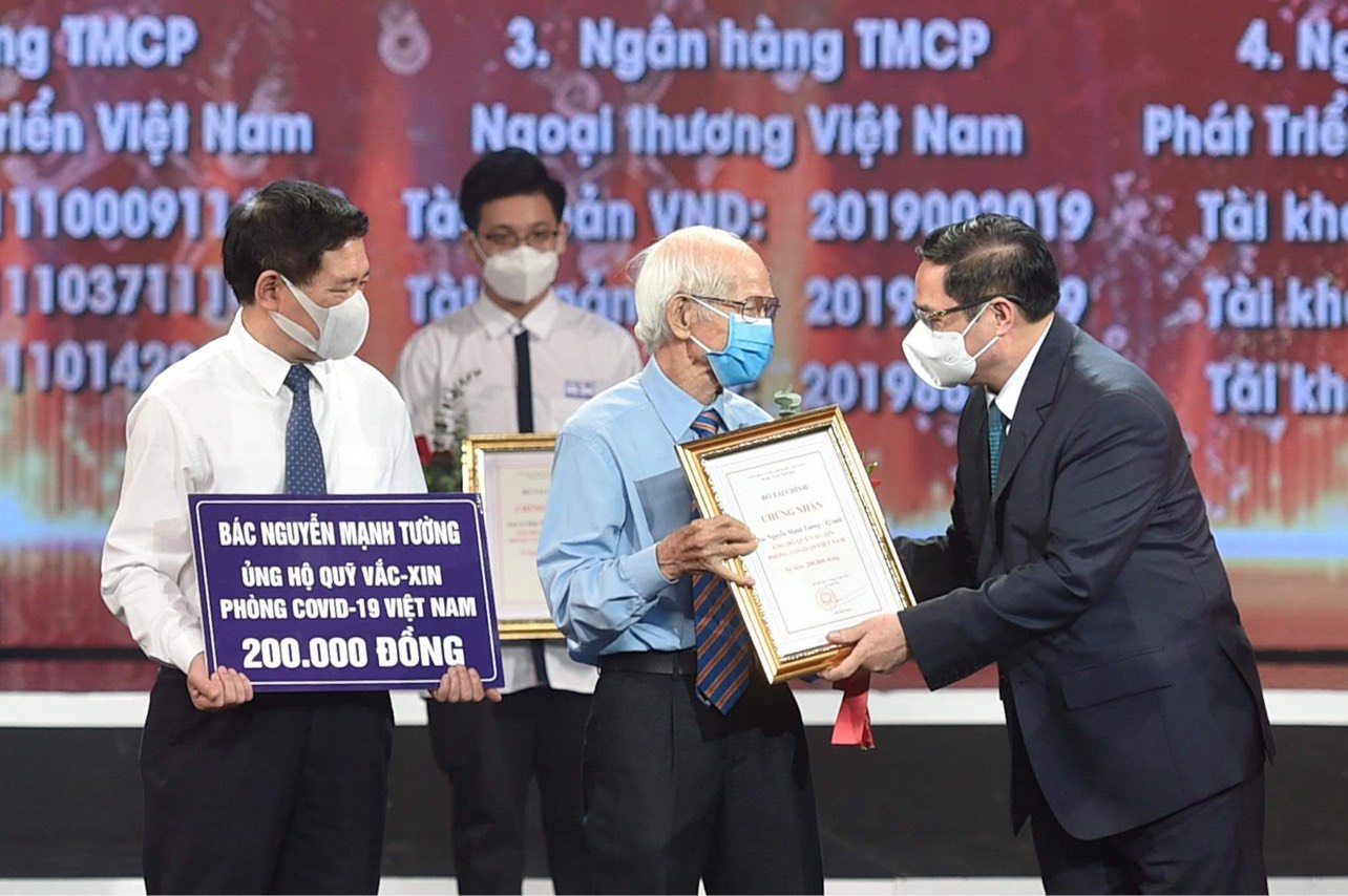 Thủ tướng Chính phủ Phạm Minh Chính trao chứng nhận, hoa cảm ơn bác Nguyễn Mạnh Tường 82 tuổi, cán bộ hưu trí ngành đường sắt.