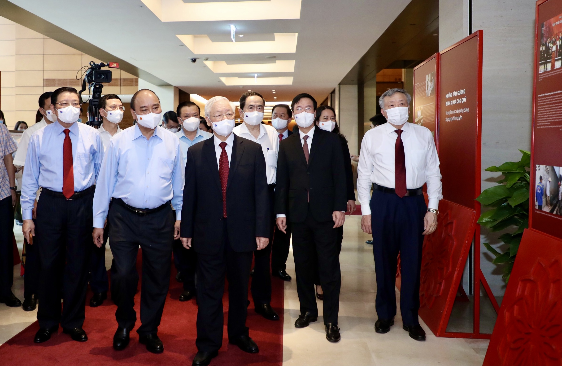 Tổng Bí thư Nguyễn Phú Trọng, Chủ tịch nước Nguyễn Xuân Phúc và các đại biểu tham quan, nghe giới thiệu Triển lãm “Những tấm gương bình dị mà cao quý”  - Ảnh: VGP/Nhật Bắc