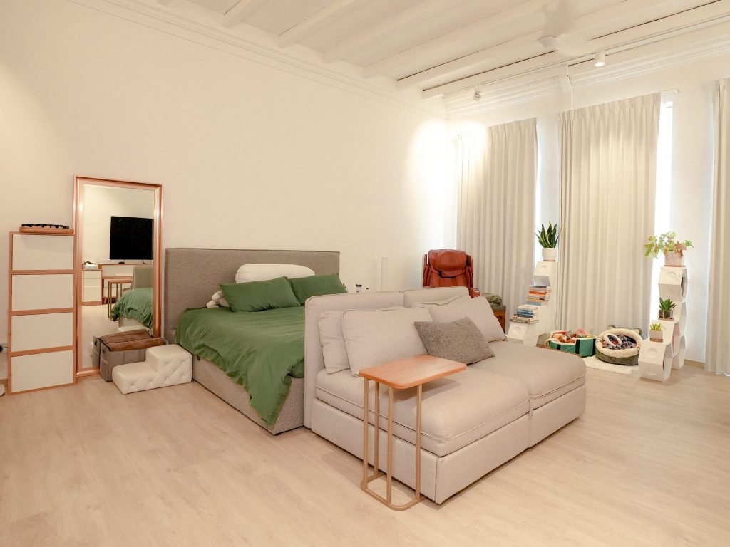 Phòng ngủ r&ocirc;̣ng rãi, nơi Sylvia và chú chó cưng của mình chia sẻ kh&ocirc;ng gian với nhau. Ngoài ra, h&ecirc;̣ th&ocirc;́ng ánh sáng và rèm được thi&ecirc;́t k&ecirc;́ đ&ecirc;̉ nơi đ&acirc;y có th&ecirc;̉ chuy&ecirc;̉n thành kh&ocirc;ng gian chụp hình quảng cáo b&acirc;́t cứ lúc nào.