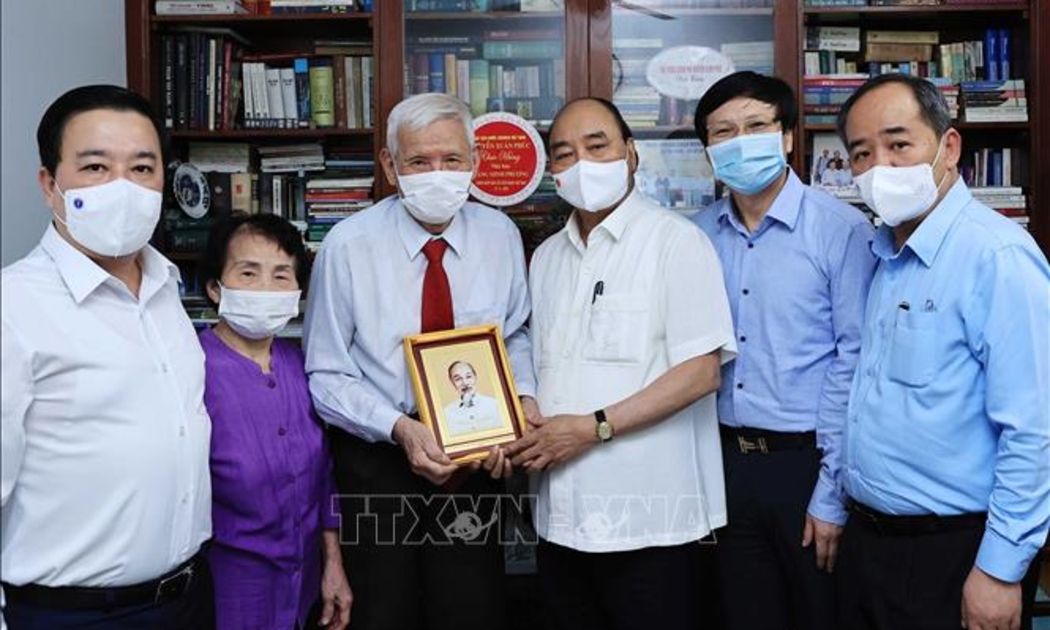 Chủ tịch nước Nguyễn Xuân Phúc đến thăm hỏi và tặng quà cho nhà báo Đặng Minh Phương - Ảnh: TTXVN