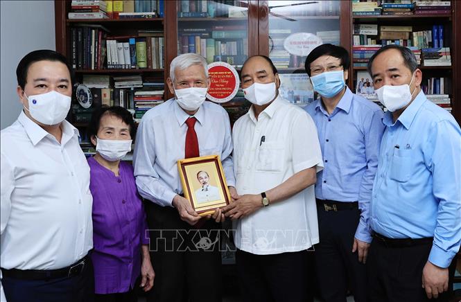 Chủ tịch nước Nguyễn Xuân Phúc đến thăm hỏi và tặng quà cho nhà báo Đặng Minh Phương - Ảnh: TTXVN