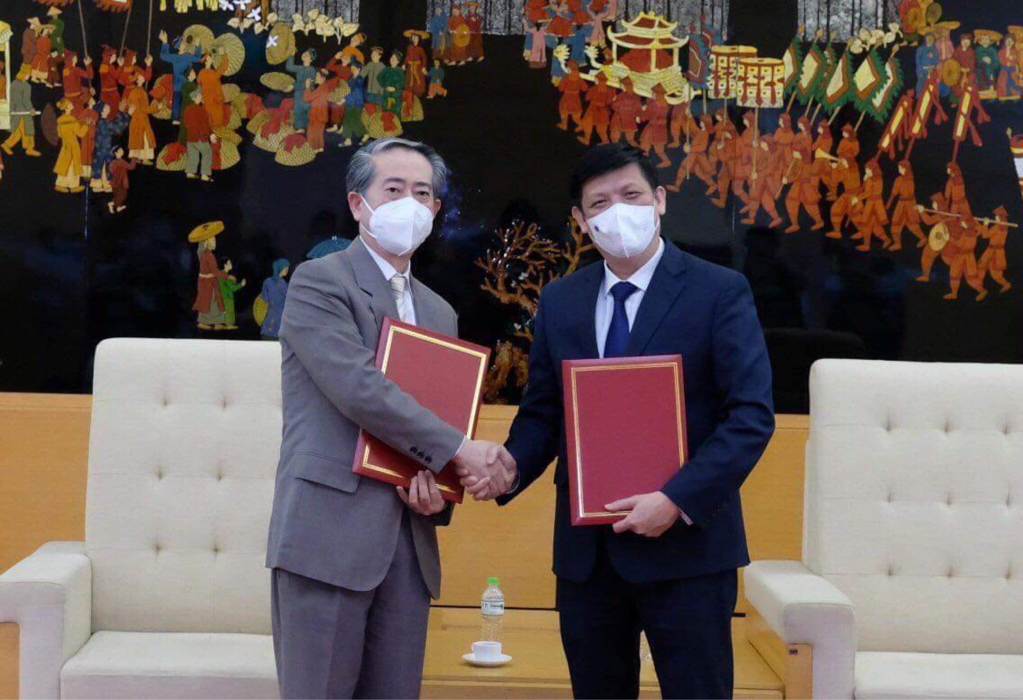 GS.TS Nguyễn Thanh Long - Bộ trưởng Bộ Y tế Việt Nam và ngài Hùng Ba - Đại sứ đặc mệnh toàn quyền nước CHND Trung Hoa - trao biên bản bàn giao lô hàng viện trợ gồm 500.000 liều vaccine và hơn 500.000 bơm kim tiêm.