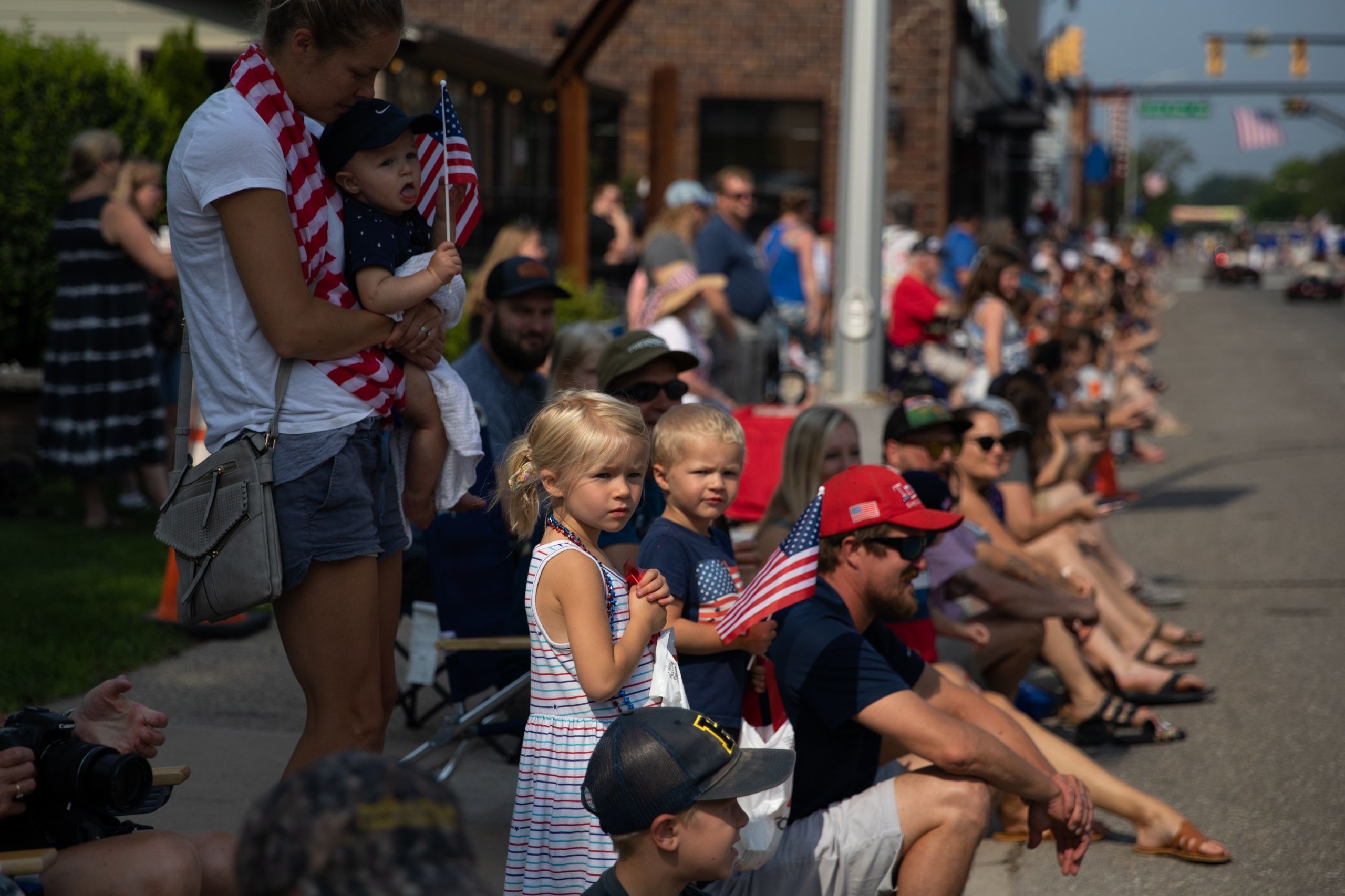 Người d&acirc;n ở Brighton, bang Michigan xuống đường chờ đ&oacute;n xem lễ diễu h&agrave;nh mừng Quốc kh&aacute;nh. C&aacute;c hoạt động lễ hội diễn ra tr&ecirc;n khắp Michigan trong dịp Quốc kh&aacute;nh Mỹ năm nay, khi bang n&agrave;y nới lỏng c&aacute;c hạn chế chống Covid - Ảnh: Getty/WSJ.