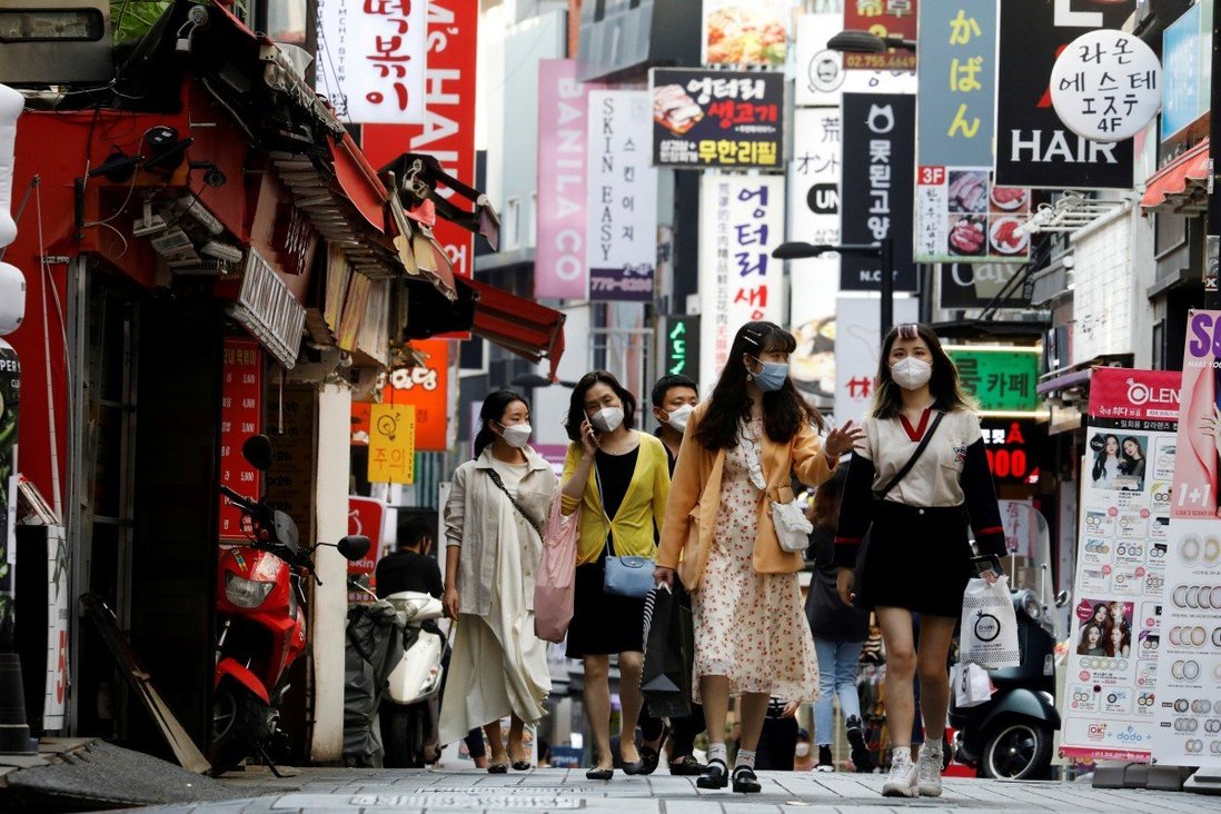 Người đi bộ tại quận mua sắm Myeongdong tại Seoul, Hàn Quốc vào tháng 5 - Ảnh: Reuters
