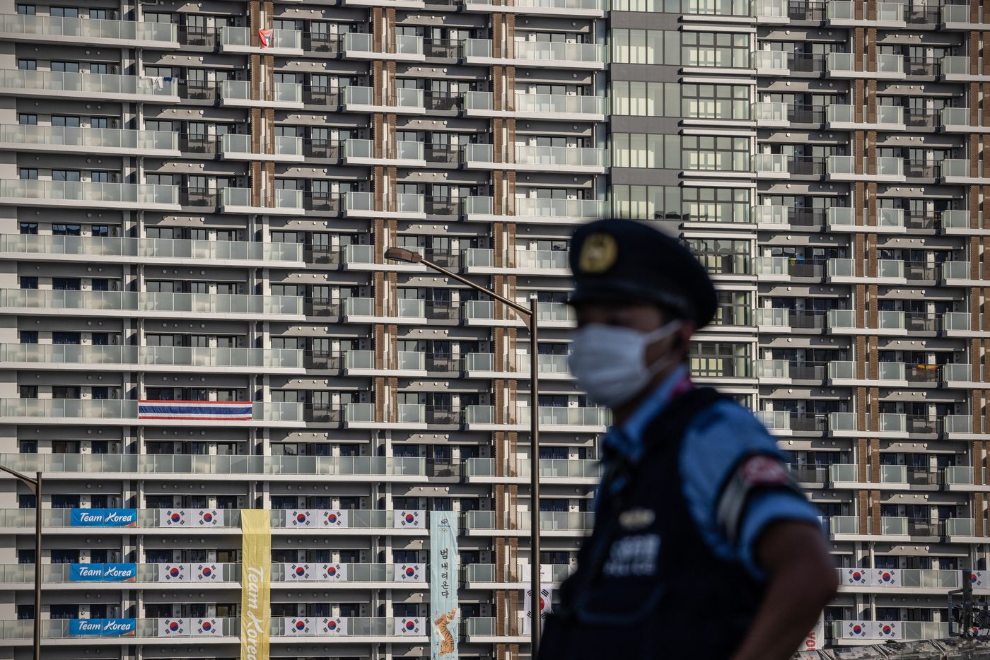 Một viên cảnh sát đứng gác tại làng vận động viên Olympic ở Tokyo - Ảnh: Getty/WSJ.