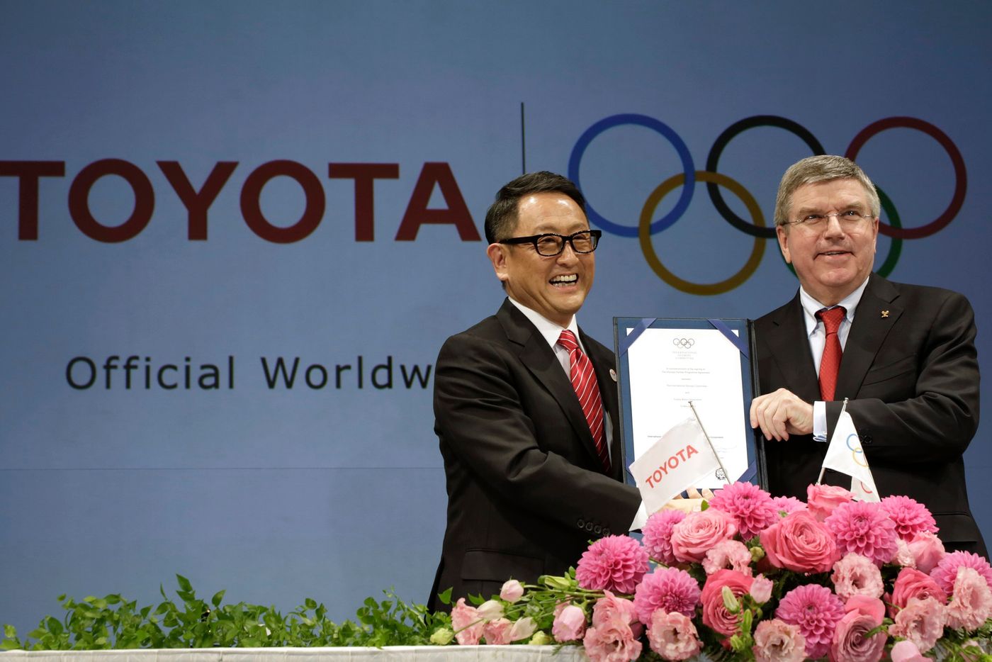 CEO Akio Toyoda của Toyota (trái) và Chủ tịch IOC Thomas Bach trong lễ ký thoả thuận vào năm 2015 đưa Toyota trở thành một nhà tài trợ toàn cầu của Thế vận hội - Ảnh: AP/WSJ.