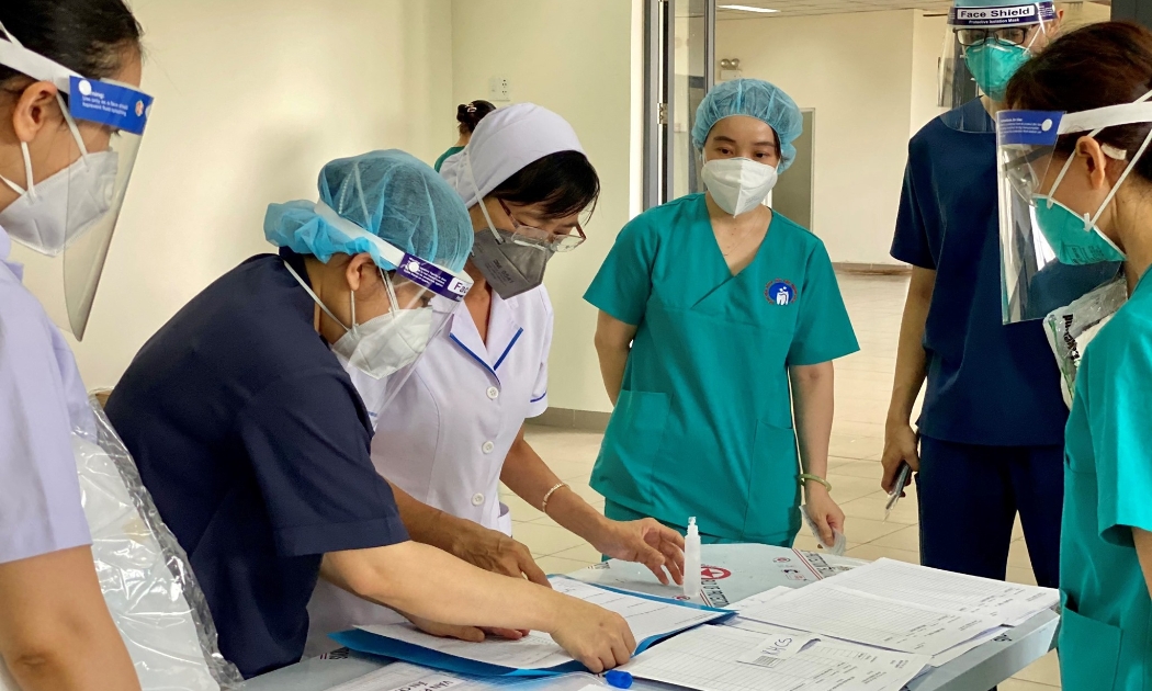 Nhân viên y tế Bệnh viện dã chiến số 2 trao đổi thông tin trước khi vào thăm khám bệnh nhân.