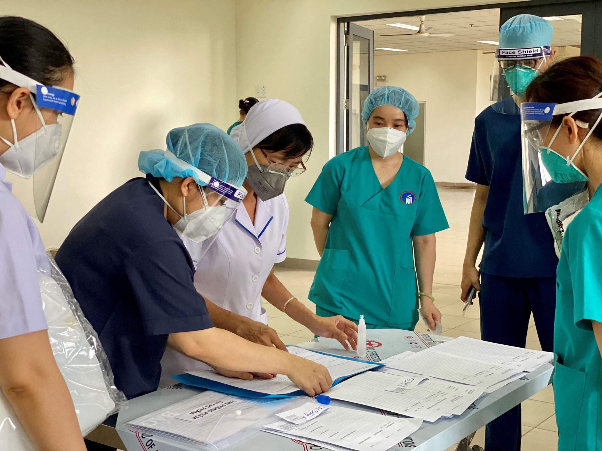 Nhân viên y tế Bệnh viện dã chiến số 2 trao đổi thông tin trước khi vào thăm khám bệnh nhân.