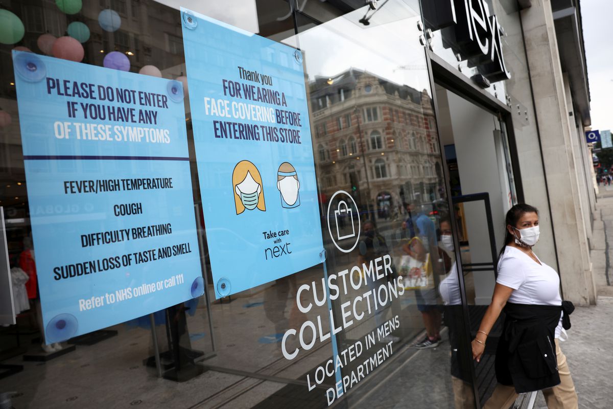 Một cửa hiệu dán thông báo đề nghị khách hàng đeo khẩu trang, ở Oxford Street, London, Anh, ngày 26/7 - Ảnh: Reuters.