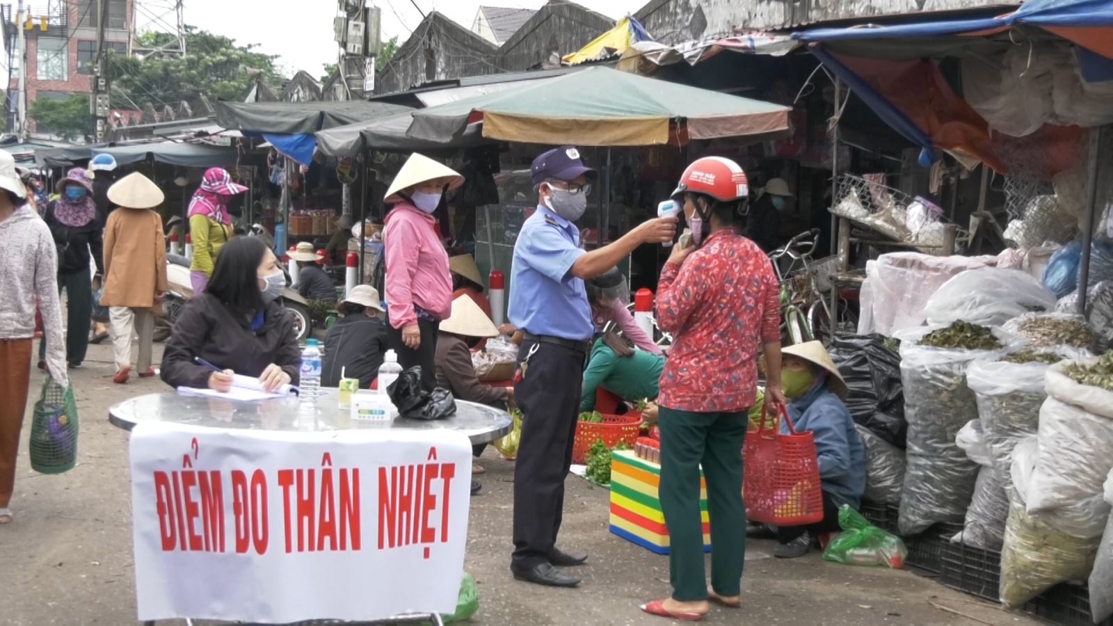 Ban quản lý chợ cần đo thân nhiệt cho người đi mua hàng tại cửa chợ.
