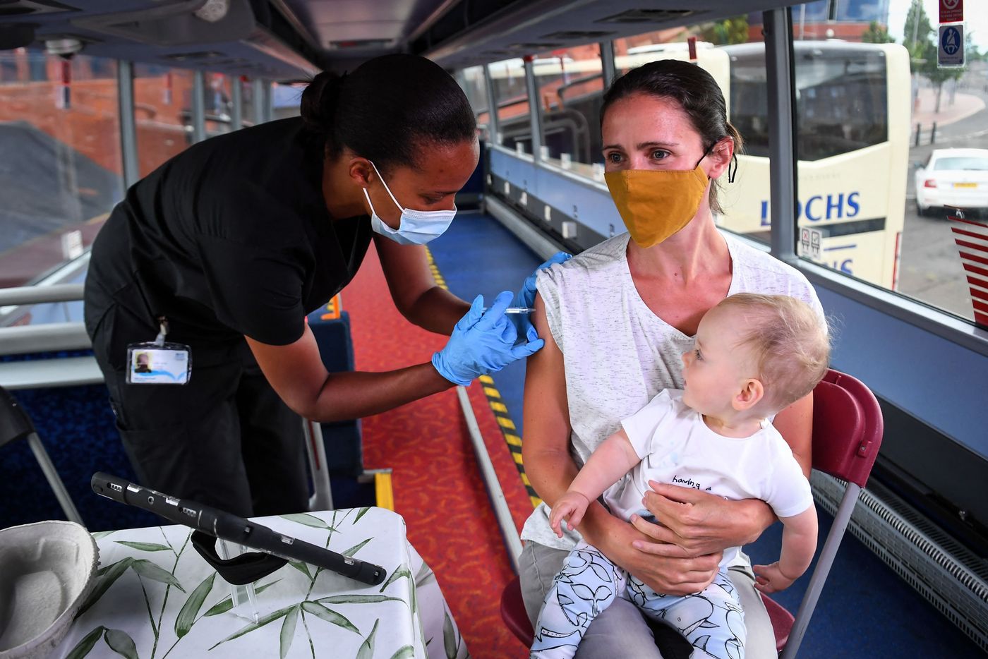 Một phụ nữ đi tiêm vaccine Covid-19 ở Glasgow, Anh - Ảnh: Getty/WSJ.