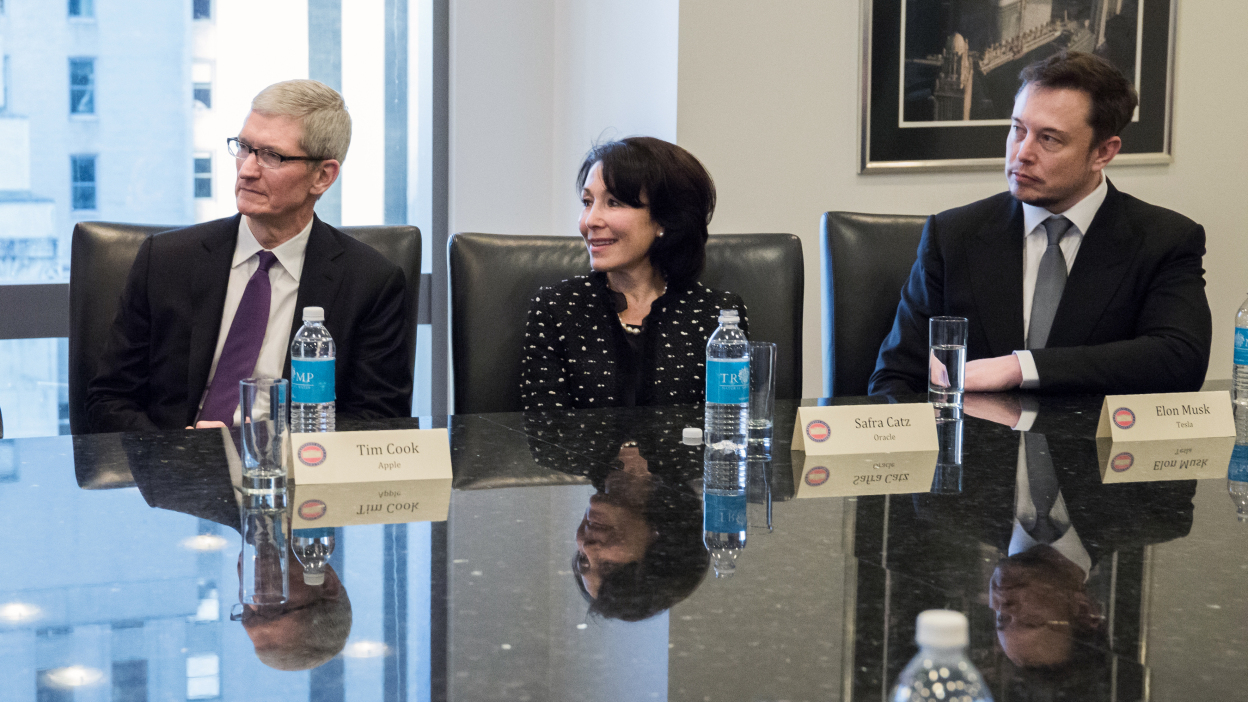Bức ảnh chụp ông Tim Cook và ông Elon Musk ngồi gần nhau vào tháng 12/2016 - Ảnh: Getty Images