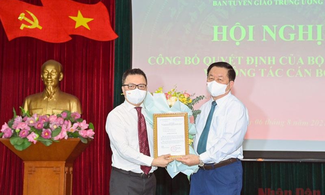 Ông Nguyễn Trọng Nghĩa, Trưởng Ban Tuyên giáo Trung ương trao quyết định và tặng hoa, chúc mừng Phó Trưởng Ban Tuyên giáo Trung ương Lê Quốc Minh. Ảnh - Duy Linh. 