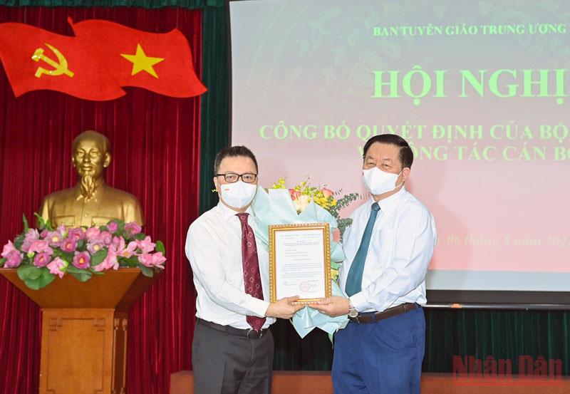 Ông Nguyễn Trọng Nghĩa, Trưởng Ban Tuyên giáo Trung ương trao quyết định và tặng hoa, chúc mừng Phó Trưởng Ban Tuyên giáo Trung ương Lê Quốc Minh. Ảnh - Duy Linh. 