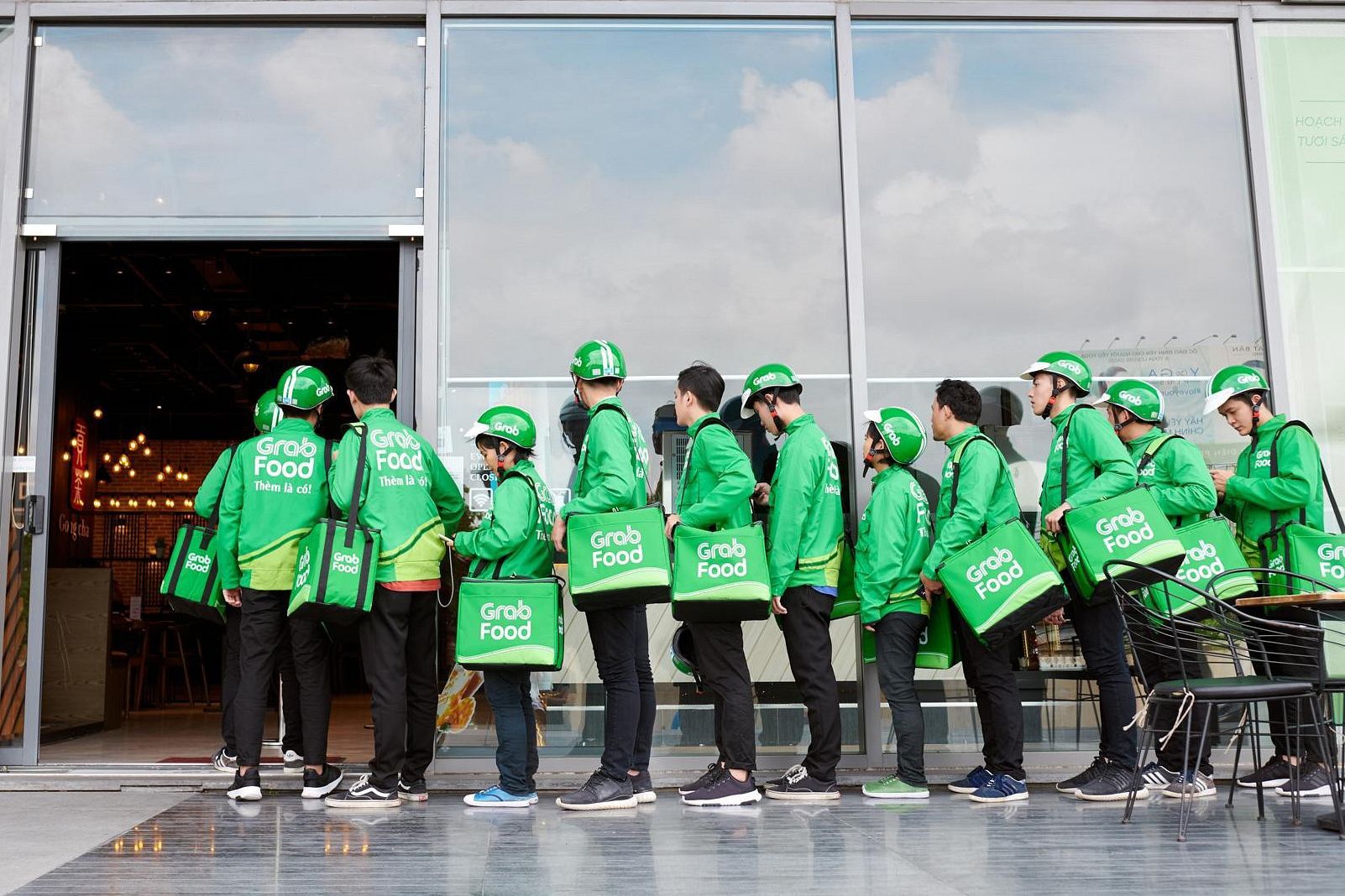 Tài xế Grabfood chờ lấy hàng tại một cửa hàng tại TP.HCM - Ảnh: Saigoneer