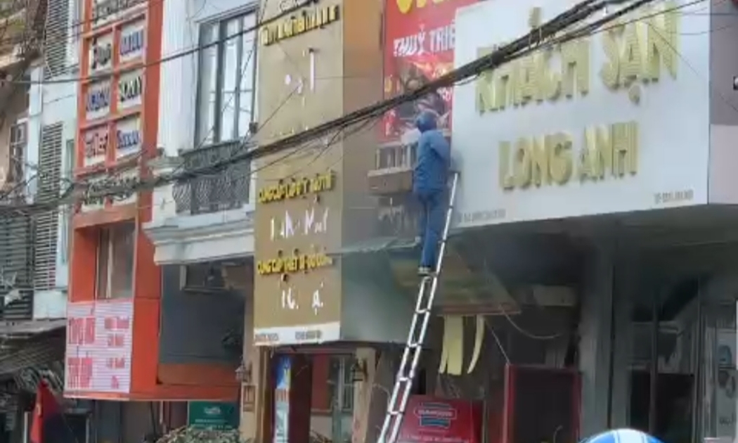 Anh Mai Đức Cảnh nhanh chóng dùng thang của VNPT lên ban công tầng 2 cứu người.