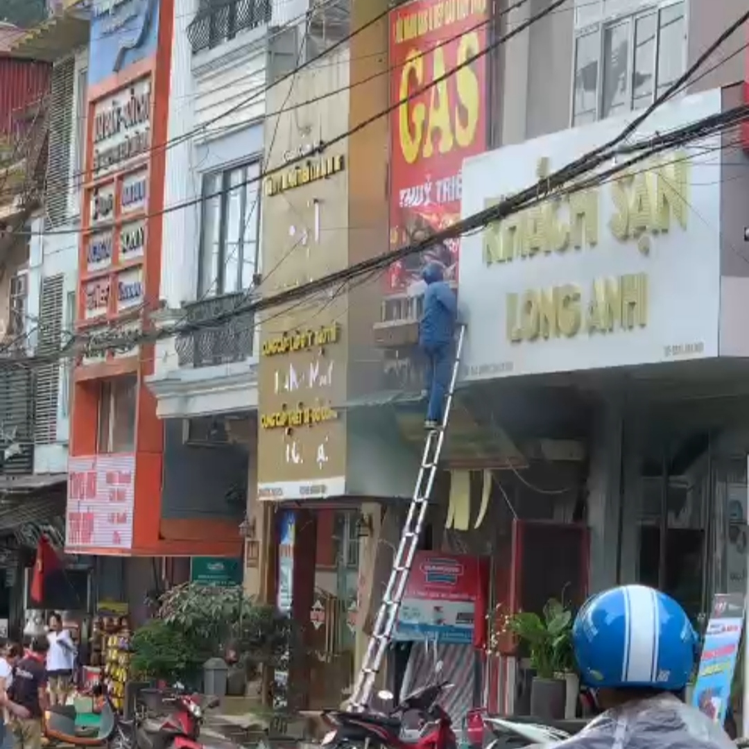 Anh Mai Đức Cảnh nhanh chóng dùng thang của VNPT lên ban công tầng 2 cứu người.