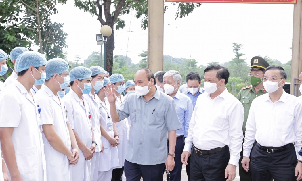 Chủ tịch nước Nguyễn Xuân Phúc tặng quà các nhân viên y tế làm việc tại cơ sở thu dung, điều trị bệnh nhân Covid-19 của Bệnh viện Đa khoa Hà Đông tại phường Hoàng Liệt, quận Hoàng Mai - Ảnh: VGP