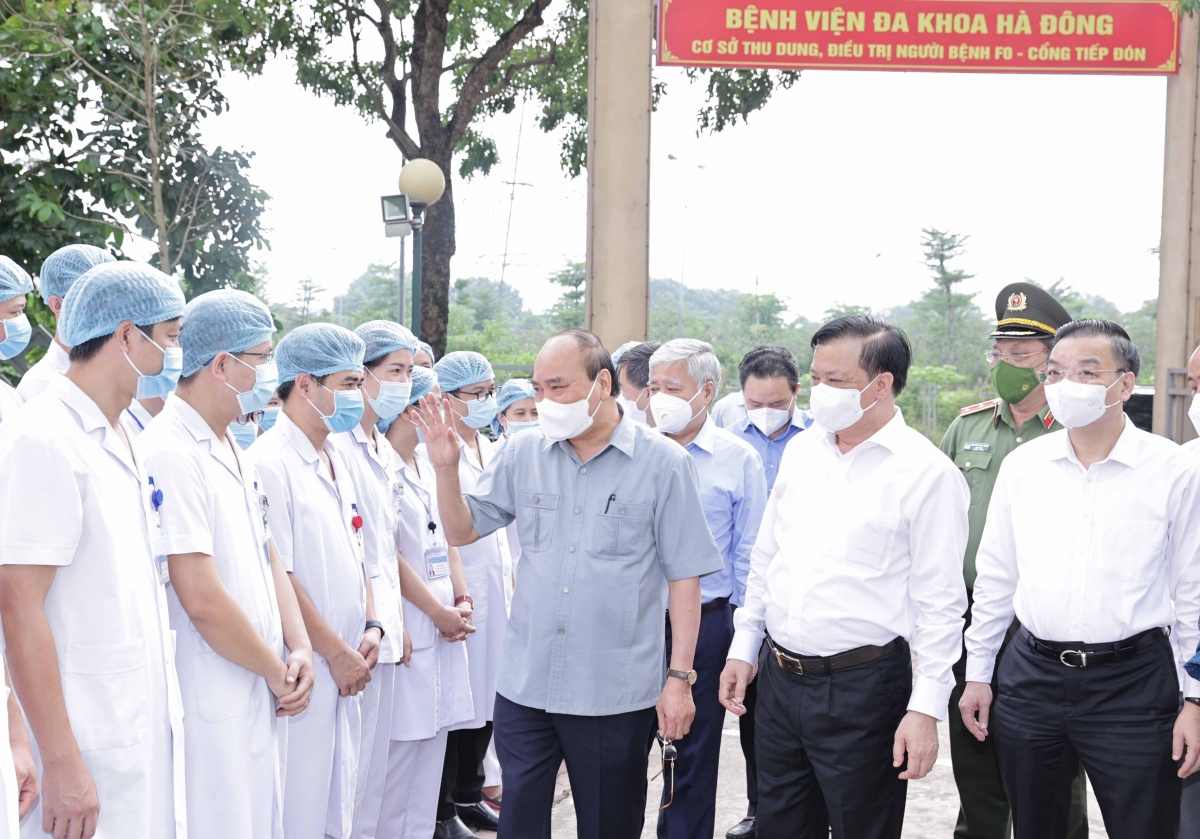 Chủ tịch nước Nguyễn Xuân Phúc tặng quà các nhân viên y tế làm việc tại cơ sở thu dung, điều trị bệnh nhân Covid-19 của Bệnh viện Đa khoa Hà Đông tại phường Hoàng Liệt, quận Hoàng Mai - Ảnh: VGP