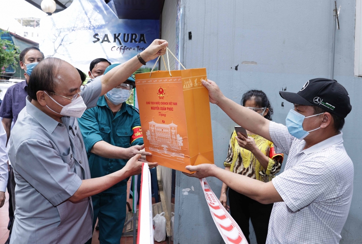 Chủ tịch nước Nguyễn Xu&acirc;n Ph&uacute;c tặng qu&agrave; người d&acirc;n ở nơi thực hiện gi&atilde;n c&aacute;ch x&atilde; hội - Ảnh: VGP
