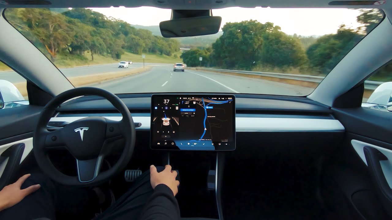 Một tài xế đang thử nghiệm công nghệ tự lái trên xe Tesla - Ảnh: Autoweek.