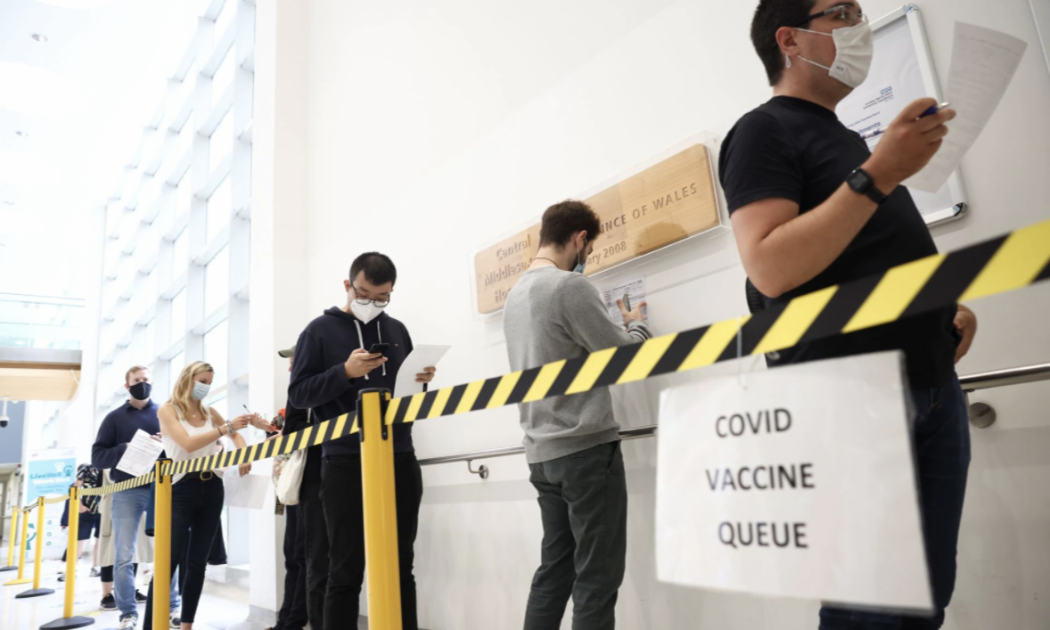Người dân xếp hàng chờ tiêm vaccine Covid-19 tại một trung tâm tiêm chủng ở London, Anh - Ảnh: Reuters.