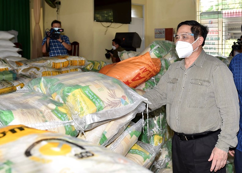 Thủ tướng tới nh&agrave; văn h&oacute;a x&atilde; Thạnh Ph&uacute;, huyện Vĩnh Cửu, nơi tập kết c&aacute;c nguồn vận động, t&agrave;i trợ để cung ứng lương thực, thực phẩm cho c&aacute;c đối tượng kh&oacute; khăn tr&ecirc;n địa b&agrave;n (Ảnh VGP).