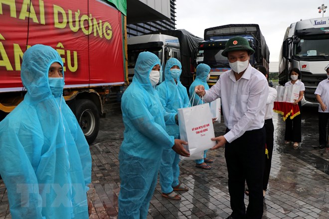 Chủ tịch UBND tỉnh Hải Dương Triệu Thế Hùng tặng quà, động viên các lái xe trước khi lên đường vận chuyển lương thực vào miền Nam. Ảnh - TTXVN.   