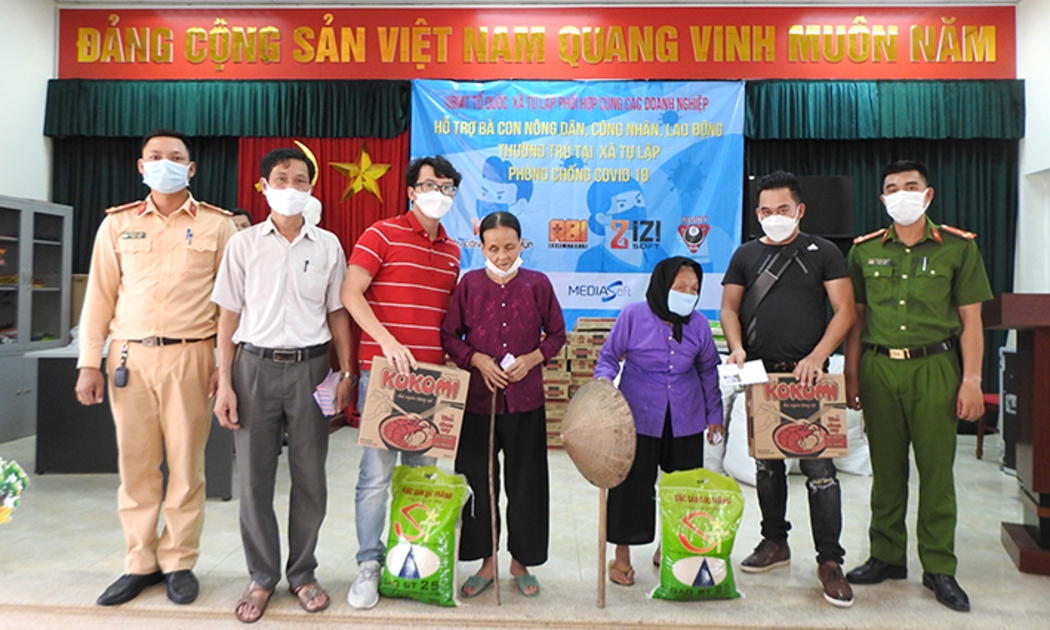 Đại diện Công ty Cổ phần Tập đoàn Viễn Đông Nga và các nhà hảo tâm trao tiền và hiện vật cho bà con nghèo có hoàn cảnh khó khăn ở xã Tự Lập (Mê Linh, Hà Nội).