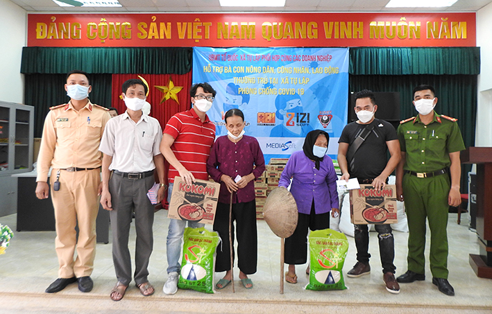 Đại diện Công ty Cổ phần Tập đoàn Viễn Đông Nga và các nhà hảo tâm trao tiền và hiện vật cho bà con nghèo có hoàn cảnh khó khăn ở xã Tự Lập (Mê Linh, Hà Nội).