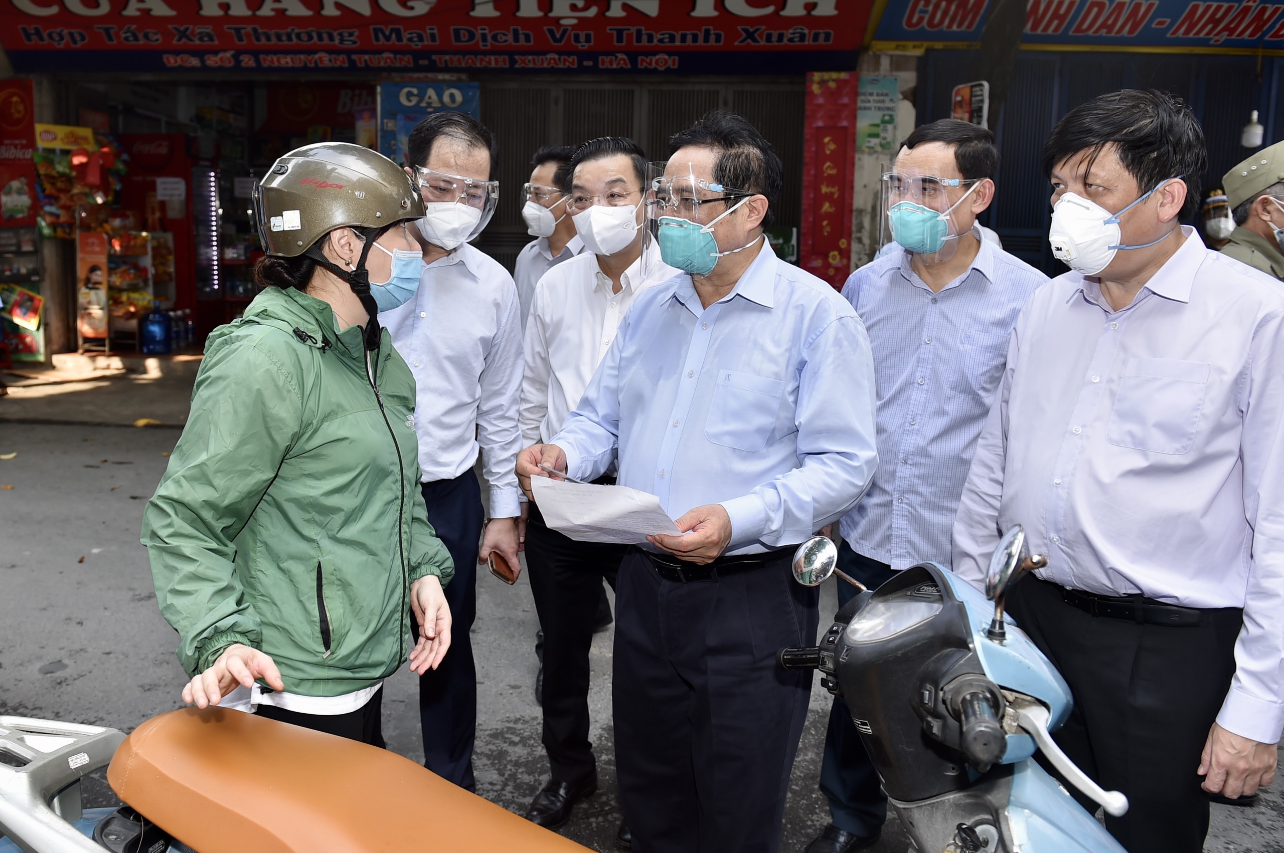 Tại đây, Thủ tướng trực tiếp trao đổi và nắm tình hình với nhiều người dân, trong đó có cả một shipper đang vận chuyển hàng trên đường. Ảnh: VGP.
