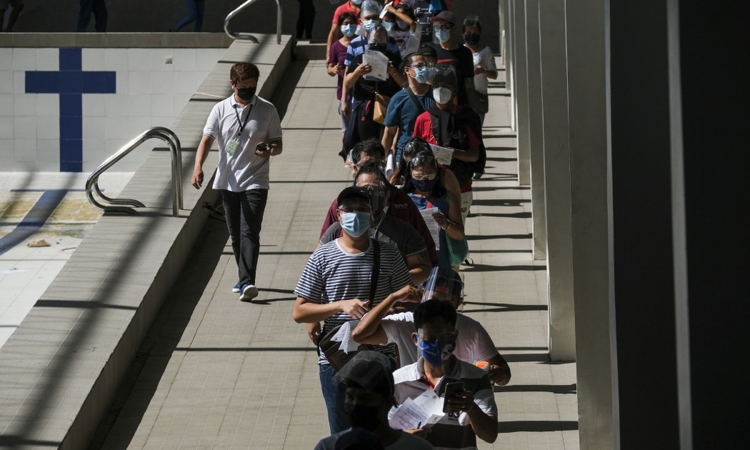 Xếp hàng chờ tiêm vaccine Covid-19 tại một điểm tiêm chủng ở Manila, Philippines hồi đầu tháng 8/2021 - Ảnh: Bloomberg.