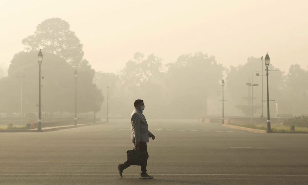 Một người đàn ông bước đi trong bầu không khí đầy khói mù ở New Delhi, Ấn Độ vào buổi sáng ngày 23/12/2020 - Ảnh: Reuters.