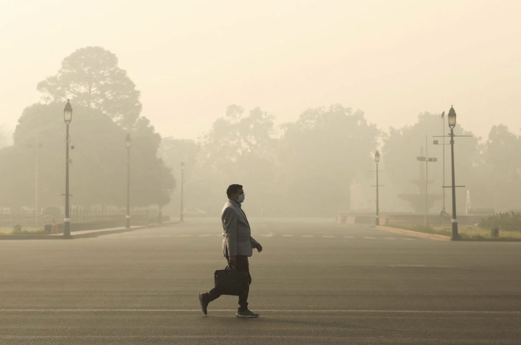 Một người đàn ông bước đi trong bầu không khí đầy khói mù ở New Delhi, Ấn Độ vào buổi sáng ngày 23/12/2020 - Ảnh: Reuters.
