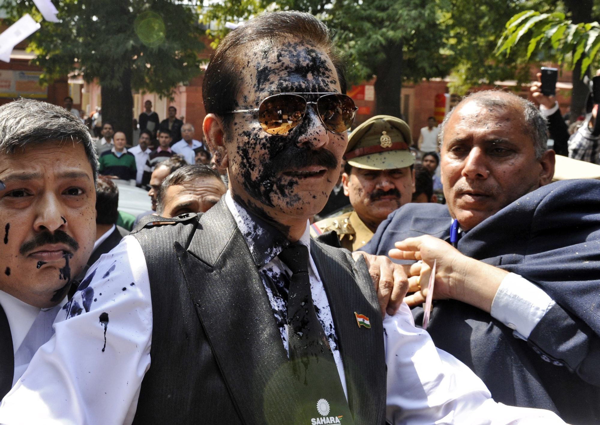 Chủ tịch tập đoàn Sahara Subrata Roy bị ném mực vào người khi đến Tòa án Tối cao ở New Delhi năm 2014 - Ảnh: Reuters