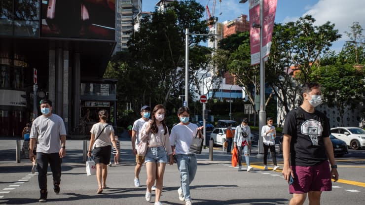 Người dân Singapore đeo khẩu trang để phòng tránh Covid-19 dù tỷ lệ tiêm phòng đạt mức cao - Ảnh: Reuters/CNBC.