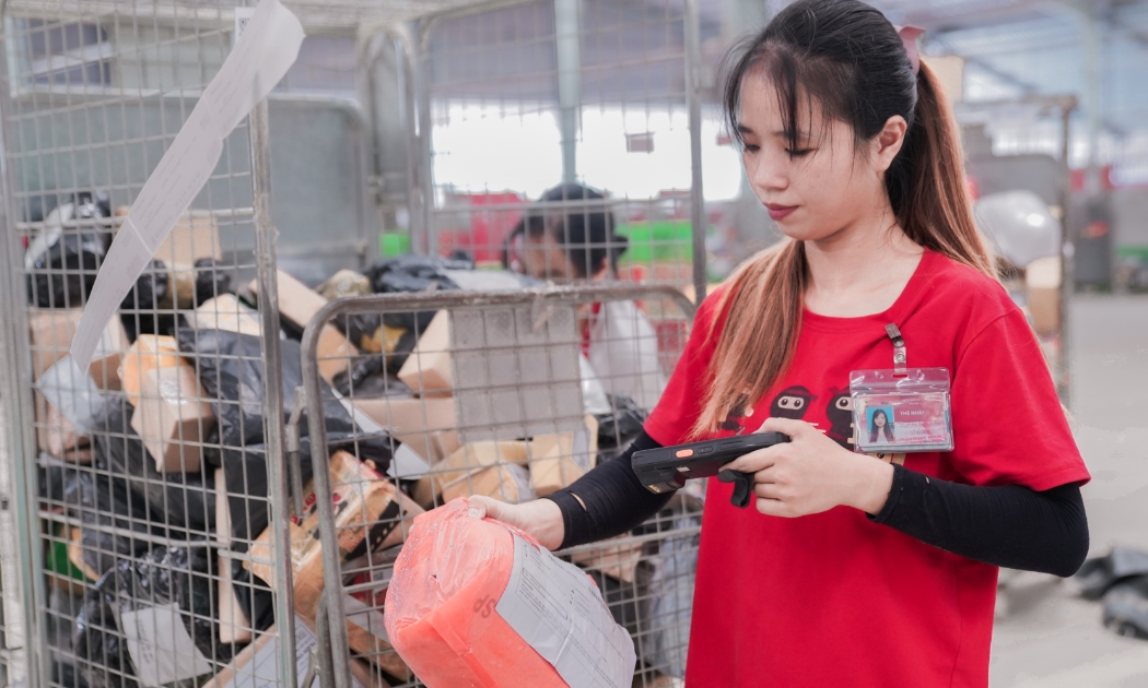 Nhân viên Ninja Van kiểm tra mã vạch truy xuất nguồn gốc hàng hóa tại kho.