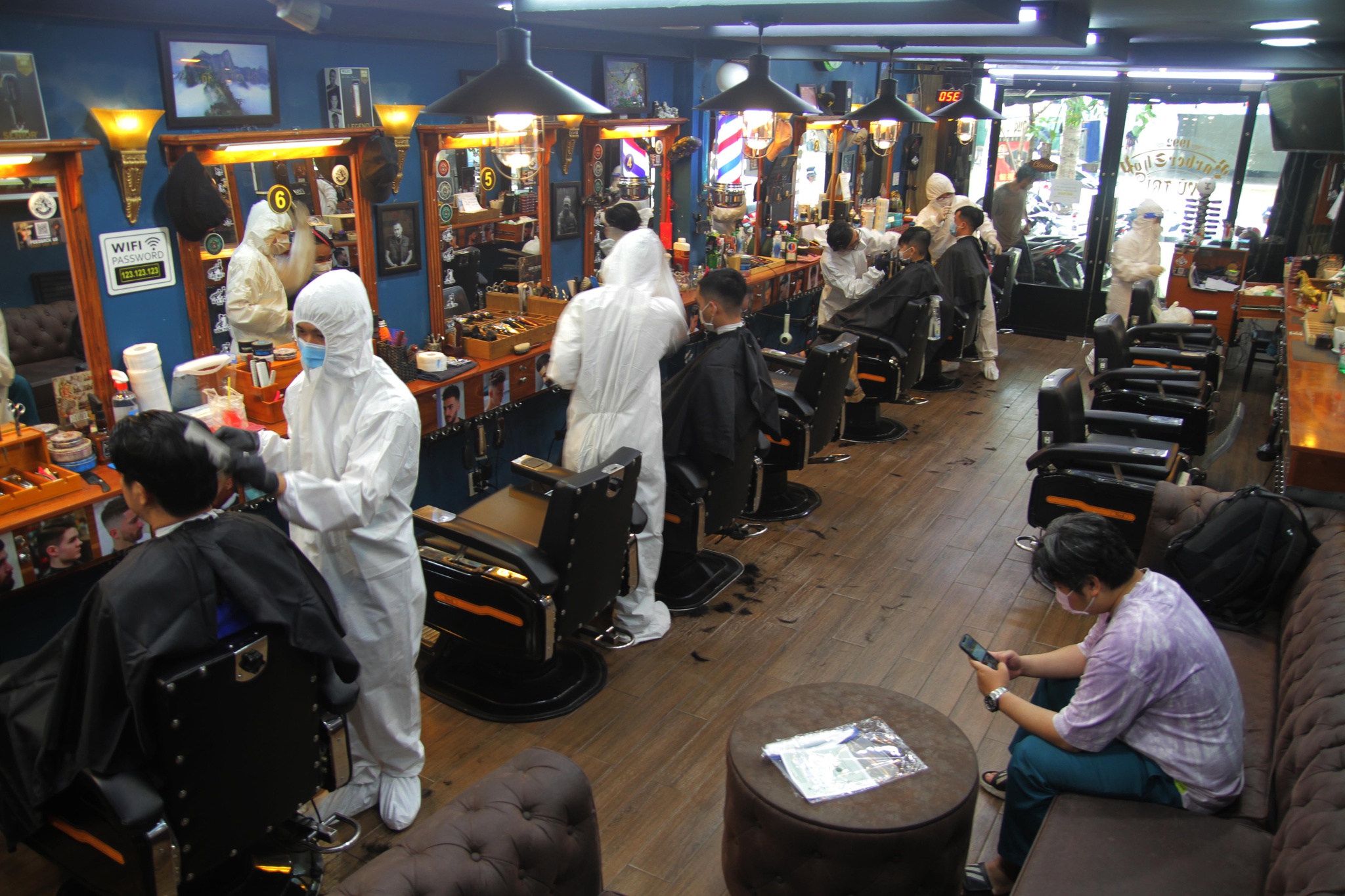 Để đảm bảo an to&agrave;n, nhiều nh&acirc;n vi&ecirc;n v&agrave; thợ cắt t&oacute;c được trang bị đồ bảo hộ chống dịch trong ng&agrave;y mở cửa trở lại. Ảnh: Dạ Thảo (b&aacute;o Thanh Ni&ecirc;n)