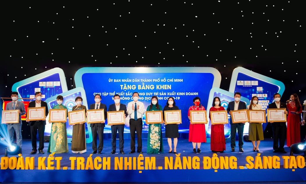 Ông Nguyễn Đình Trung - Chủ tịch Tập đoàn Hưng Thịnh (thứ sáu từ trái qua) đón nhận Bằng khen từ ông Phan Văn Mãi - Chủ tịch UBND TP.HCM dành cho 10 tập thể xuất sắc trong duy trì sản xuất kinh doanh và phòng, chống dịch bệnh Covid-19.