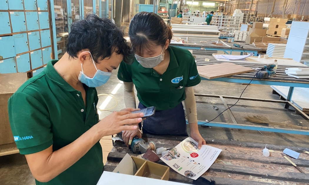 Nhân viên 1 doanh nghiệp sản xuất gỗ nhận lương hàng ngày qua ứng dụng điện thoại.