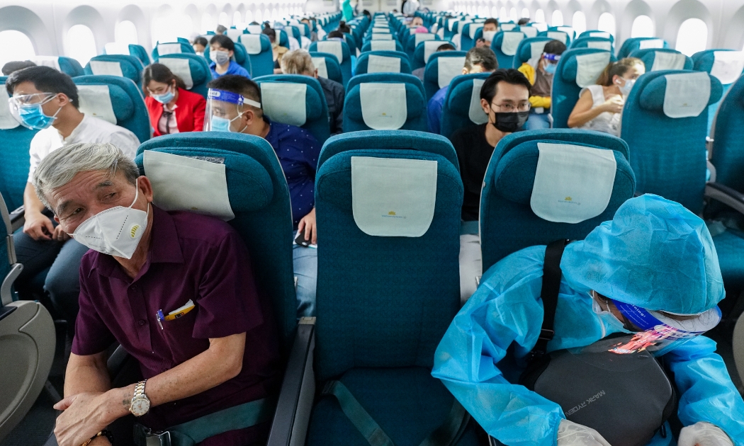 Hành khách trên chuyến bay của Vietnam Airlines thực hiện ngồi giãn cách ghế theo đúng quy định.