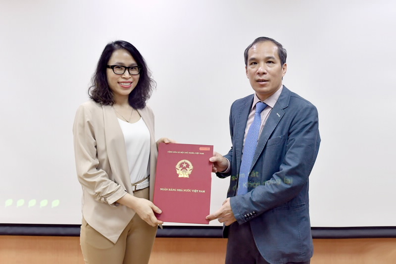 Phó Thống đốc Đoàn Thái Sơn (phải) trao quyết định bổ nhiệm cho bà Vũ Thuý Ngọc (trái)