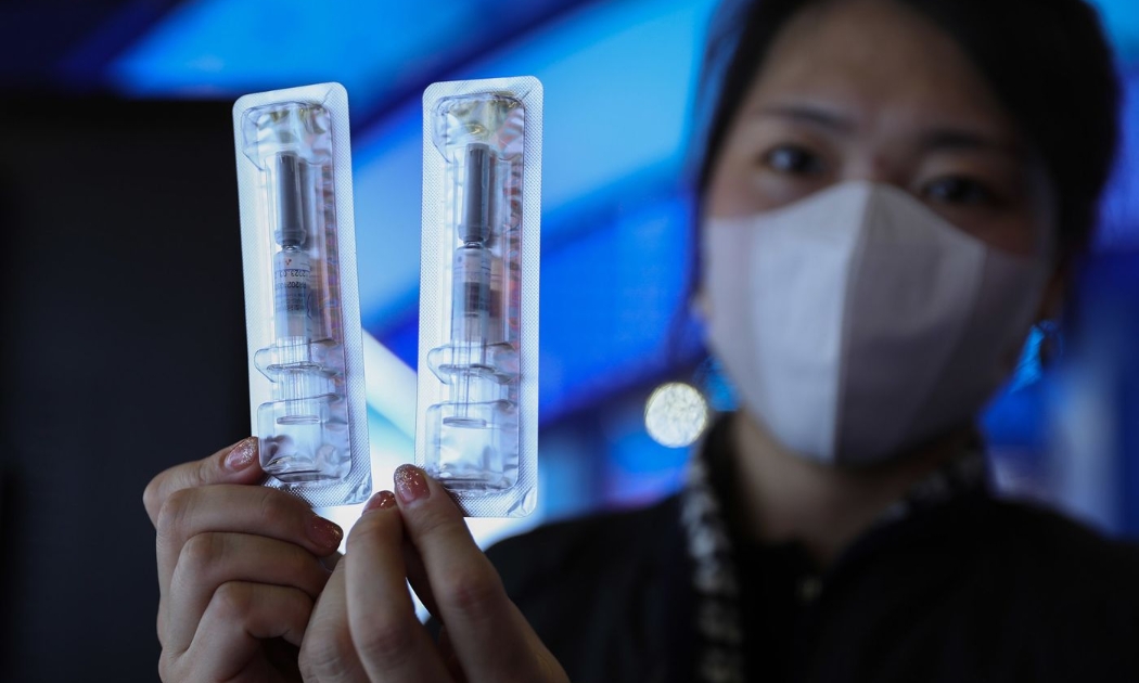 Một nhân viên công ty Walvax đang cầm vaccine Covid-19 của công ty - Ảnh: Getty Images