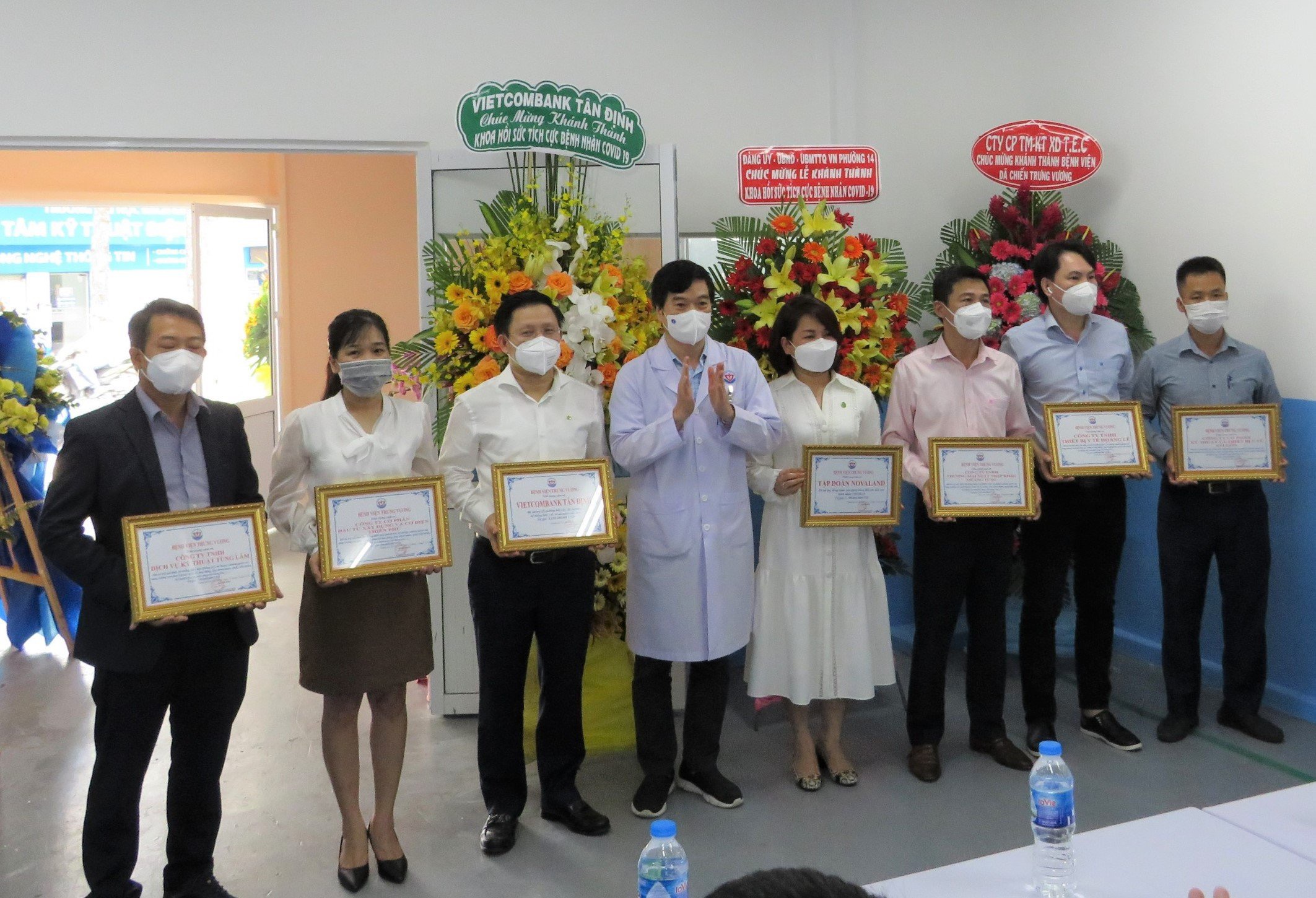 TS-BS Lê Thanh Chiến - Giám đốc Bệnh viện điều trị Covid-19 Trưng Vương (thứ 4 từ trái sang) trao thư cảm ơn đến ông Ngô Minh Nhựt - Giám đốc Vietcombank Tân Định (thứ 3 từ trái sang) cùng các đơn vị đồng hành.