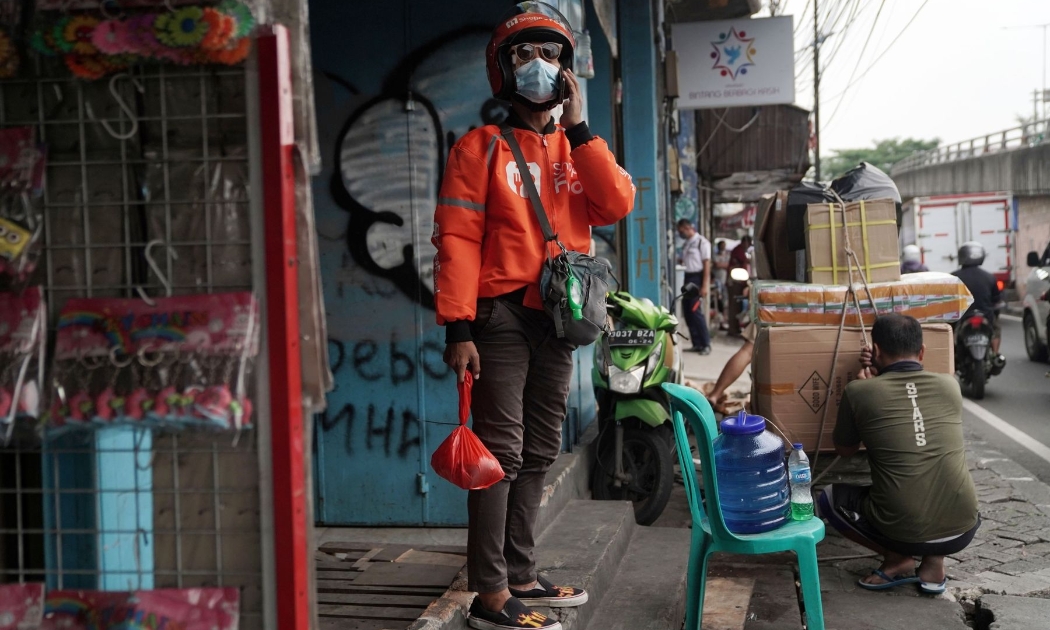 Một nhân viên Shopee giao hàng thực phẩm ở Jakarta, Indonesia - Ảnh: Bloomberg.